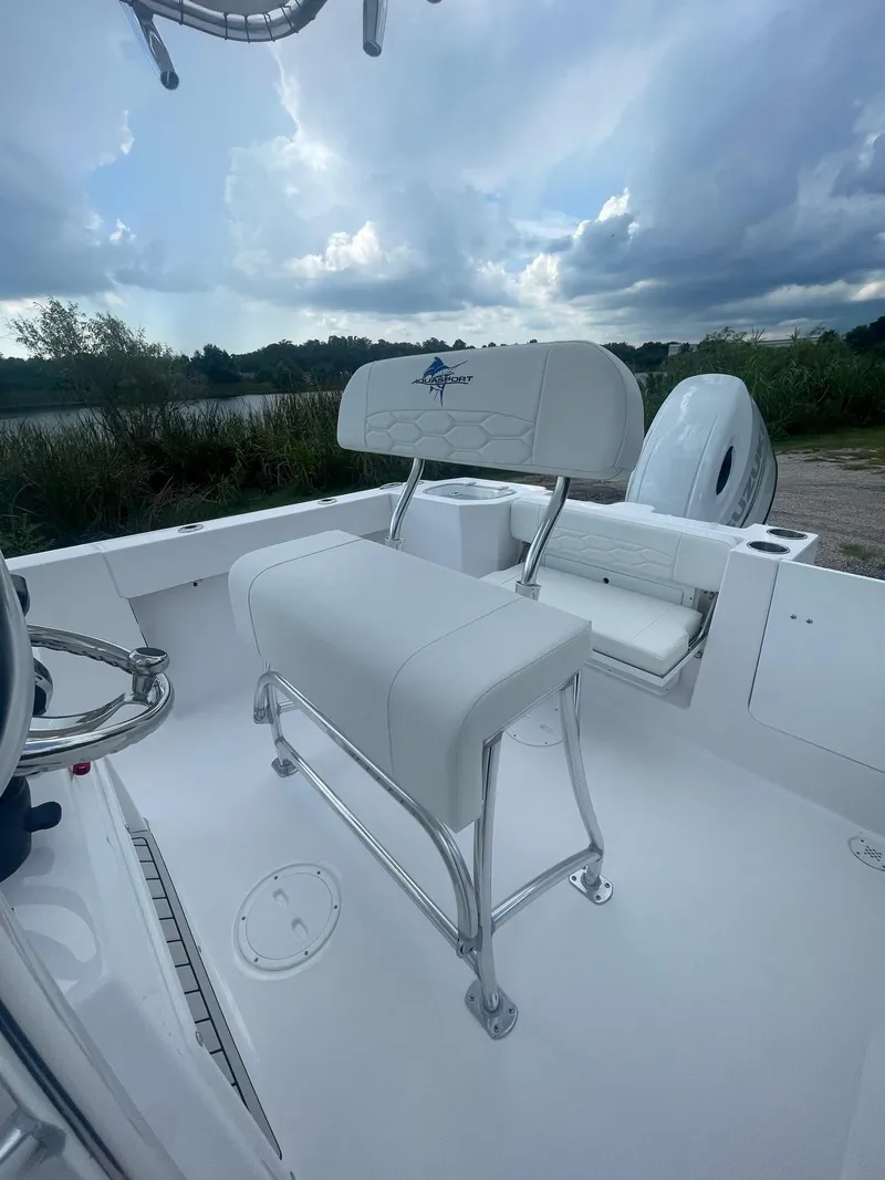 Slide: The Image of 2024 Aquasport 220 CC boat interior with white seating and sleek design. - 3