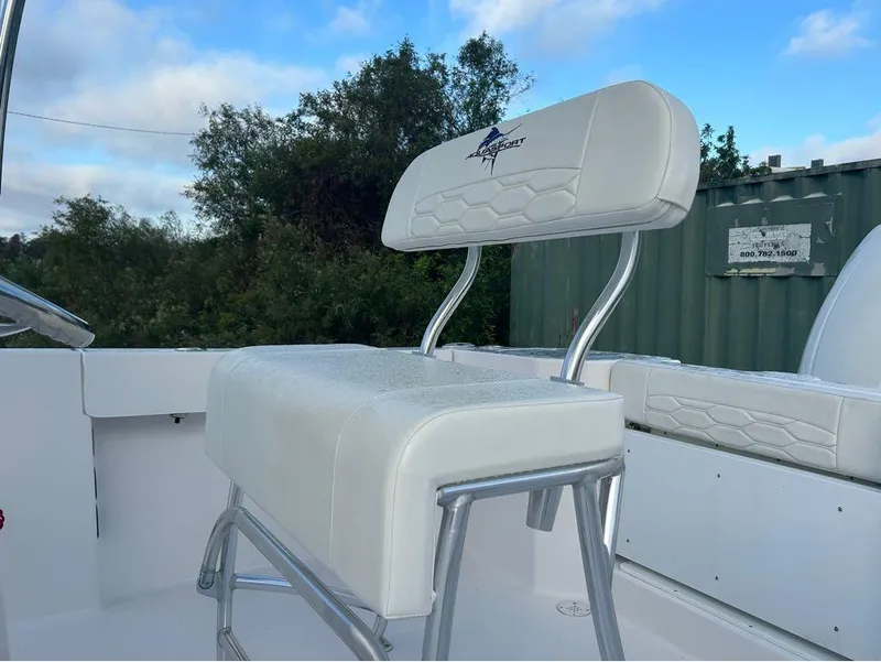 Slide: The Image of 2024 Aquasport 2200 CC boat seat with logo, white upholstery, and metal frame. - 8