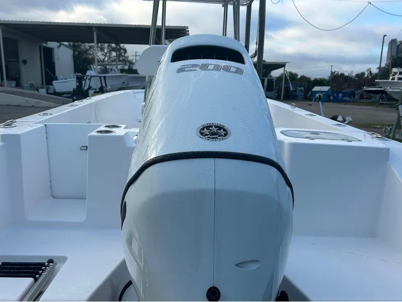 Slide: The Image of 2024 Aquasport 2200 CC boat with powerful outboard motor, docked at marina. - 9