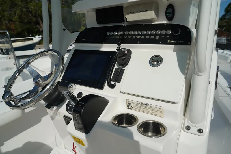Slide: The Image of 2015 Everglades 243 CC boat console with steering wheel and navigation controls. - 12