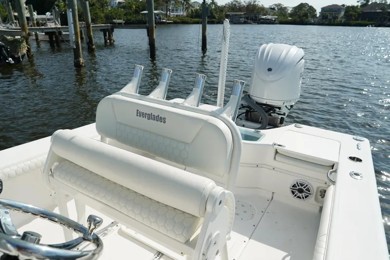 Slide: The Image of 2015 Everglades 243 CC boat interior with white seating and outboard motor on water. - 7