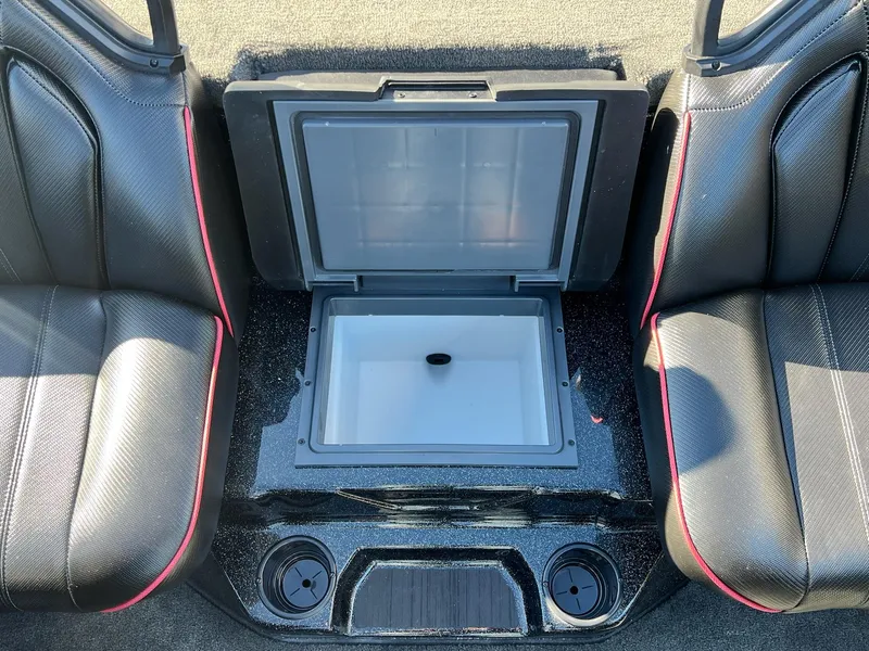 Slide: The Image of 2025 Skeeter ZXR 21 boat interior with open storage compartment and cup holders. - 23