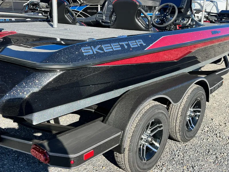 Slide: The Image of 2025 Skeeter ZXR 21 boat with sleek design and dual-axle trailer. - 26