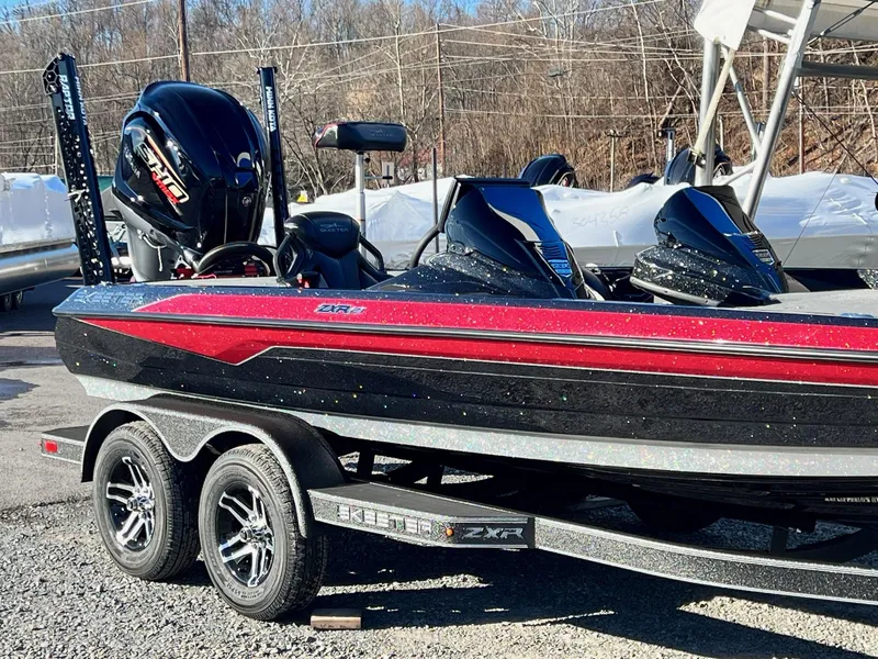 Slide: The Image of 2025 Skeeter ZXR 21 boat with dual engines on a trailer, parked outdoors. - 42