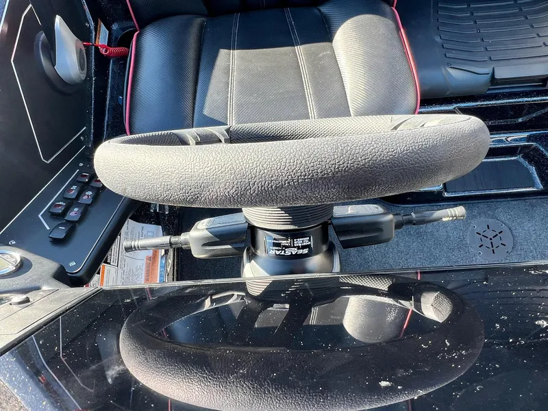 Slide: The Image of Steering wheel of 2025 Skeeter ZXR 21 boat, featuring sleek black interior design. - 43