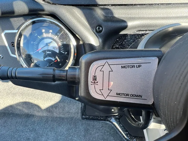 Slide: The Image of Close-up of Skeeter ZXR 21 boat controls, featuring RPM gauge and motor adjustment lever. - 44