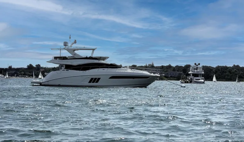 Slide: The Image of 2016 Sea Ray L590 Fly yacht on calm water under blue sky. - 1
