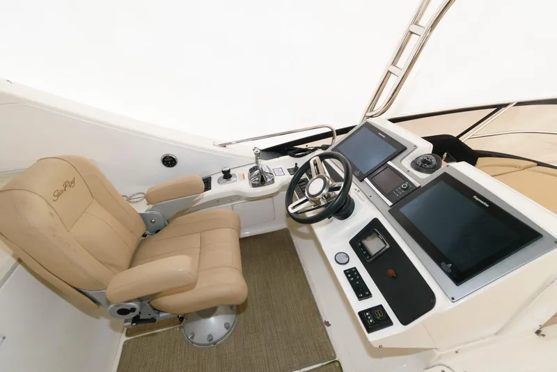 Slide: The Image of 2016 Sea Ray L590 Flybridge helm with beige captain's chair and modern controls. - 13