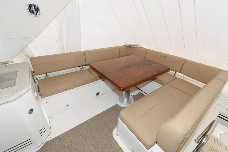 Slide: The Image of 2016 Sea Ray L590 Fly yacht interior with beige seating and wooden table. - 14