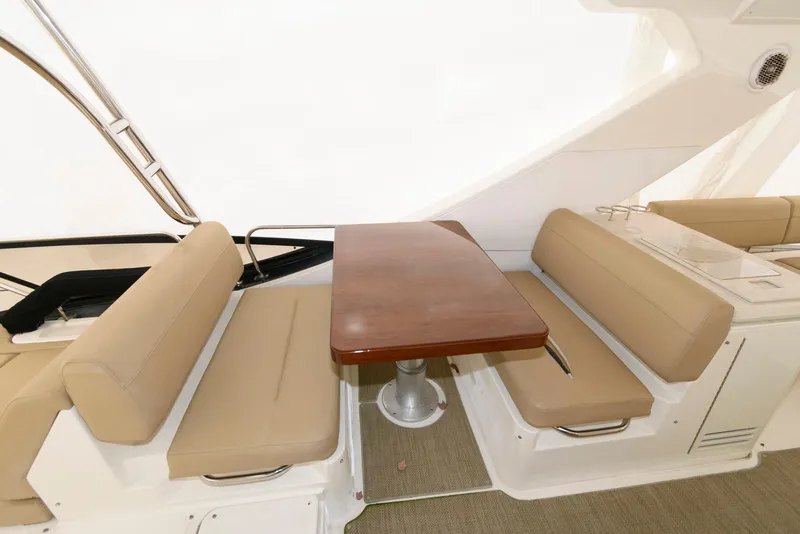 Slide: The Image of Luxurious seating area on 2016 Sea Ray L590 Fly yacht with wooden table. - 15