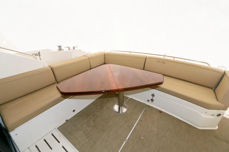 Slide: The Image of 2016 Sea Ray L590 Fly yacht interior with beige seating and triangular wooden table. - 7