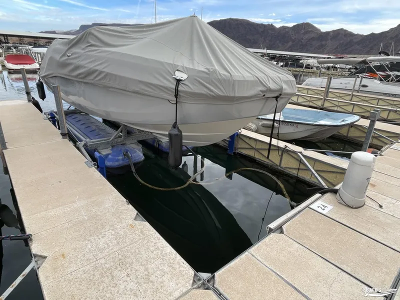 Slide: The Image of Covered 2021 Bayliner DX 2250 boat docked at marina with scenic mountain backdrop. - 11