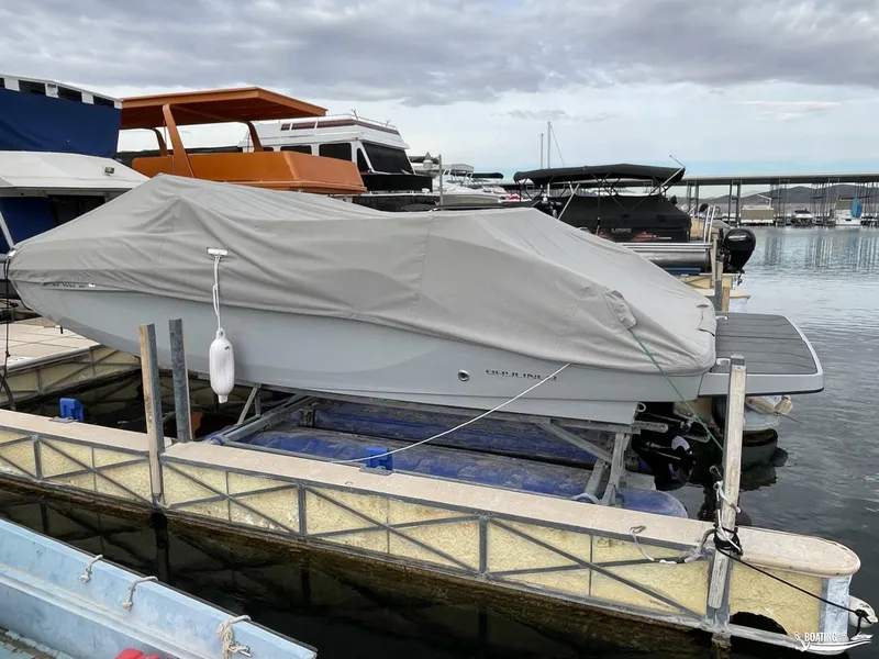 Slide: The Image of 2021 Bayliner DX 2250 boat covered at marina dock under cloudy sky. - 13