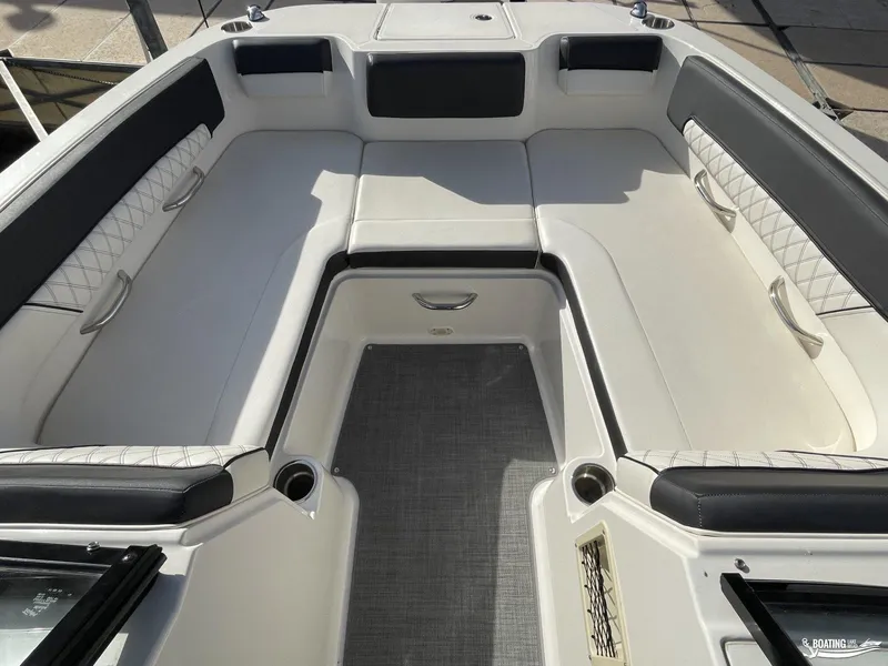 Slide: The Image of 2021 Bayliner DX 2250 boat interior with white cushioned seating and storage compartments. - 5