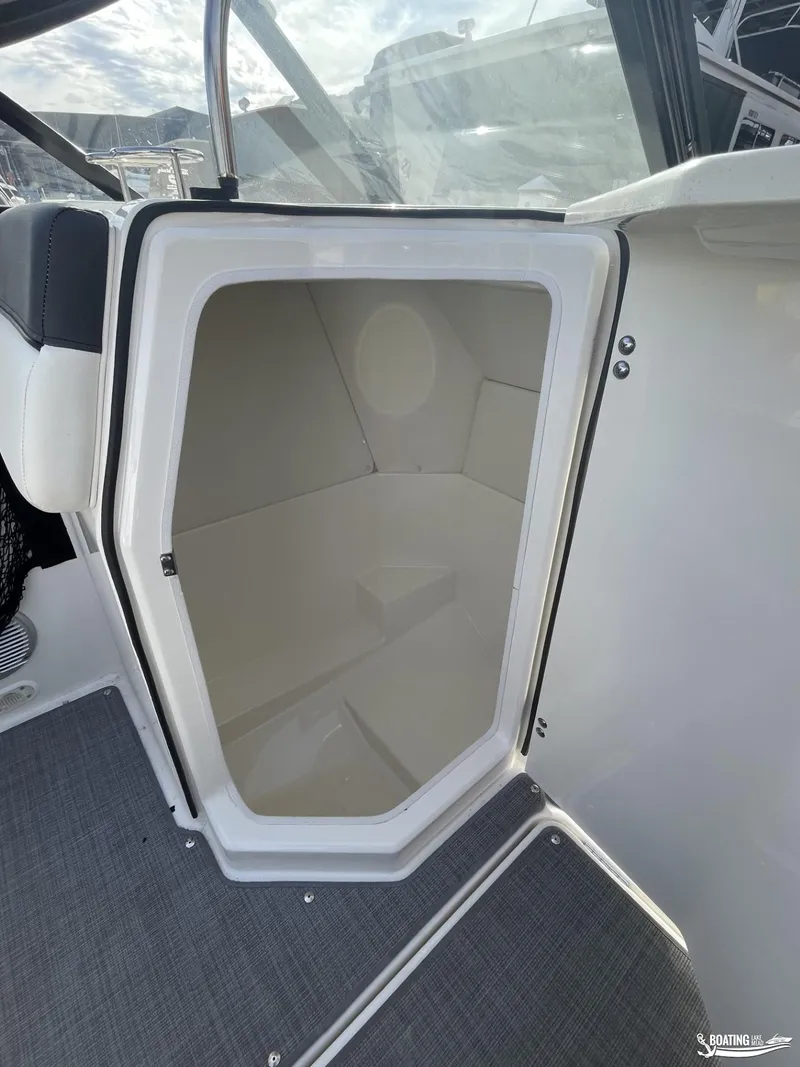 Slide: The Image of 2021 Bayliner DX 2250 boat interior storage compartment with open door. - 8