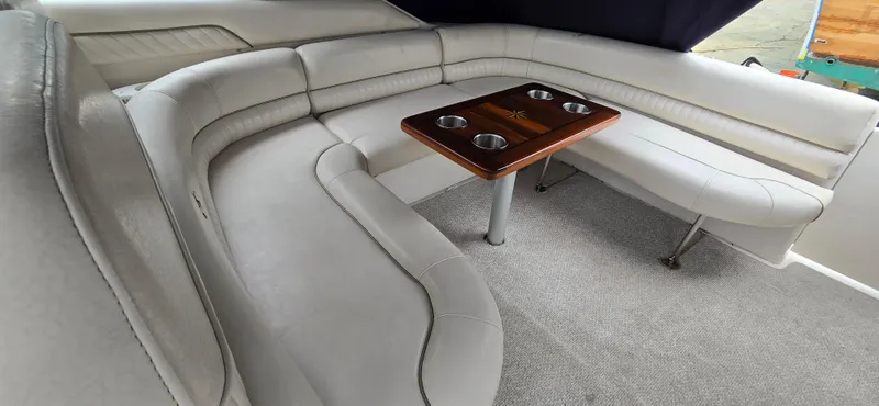 Slide: The Image of Luxurious seating area in a 2002 Monterey 322 Cruiser with a wooden table. - 16
