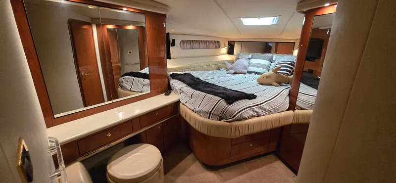 Slide: The Image of Luxurious bedroom interior of 1999 Sea Ray 50 Sundancer yacht with cozy bed and vanity. - 21