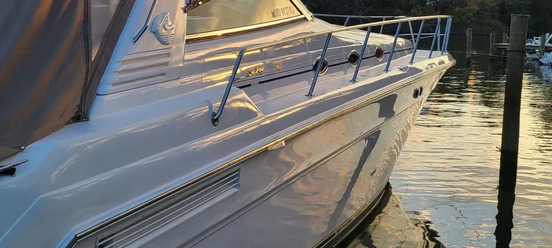 Slide: The Image of 1999 Sea Ray 50 SUNDANCER yacht docked at sunset, reflecting on calm water. - 4