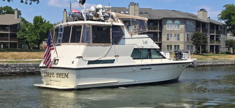 Slide: The Image of 1989 Hatteras 40 Double Cabin yacht cruising near waterfront homes. - 1