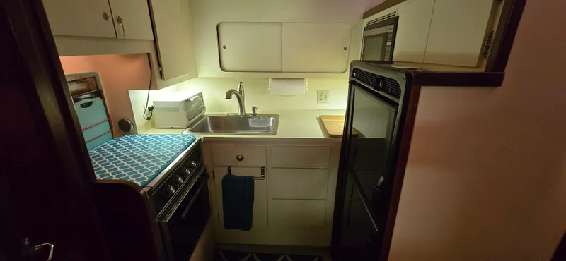 Slide: The Image of Compact kitchen in 1989 Hatteras 40 Double Cabin yacht with stove, sink, and cabinets. - 11