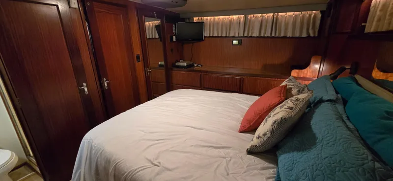 Slide: The Image of Cozy bedroom in 1989 Hatteras 40 Double Cabin yacht with wood paneling and TV. - 15