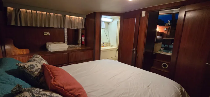 Slide: The Image of Cozy bedroom in 1989 Hatteras 40 Double Cabin yacht with wood paneling and ensuite bathroom. - 16