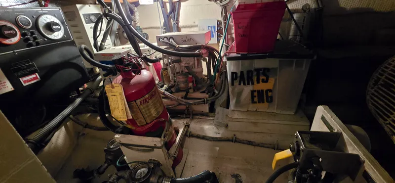 Slide: The Image of Engine room of 1989 Hatteras 40 Double Cabin with fire extinguisher and parts storage. - 22