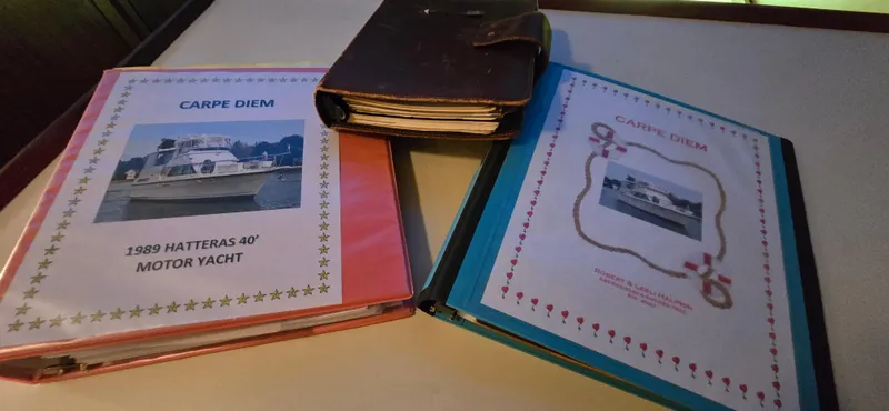 Slide: The Image of Binders and notebook featuring 1989 Hatteras 40 Double Cabin yacht "Carpe Diem" documentation. - 25