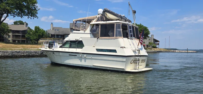 Slide: The Image of 1989 Hatteras 40 Double Cabin yacht on calm water near shoreline. - 4