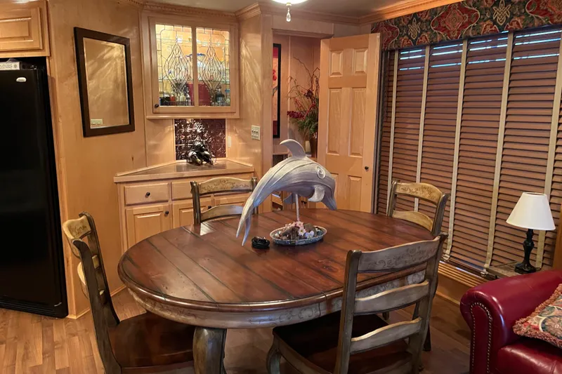 Slide: The Image of Cozy dining area with wooden table, dolphin sculpture, and warm lighting in a Funtime 68x16 model. - 11