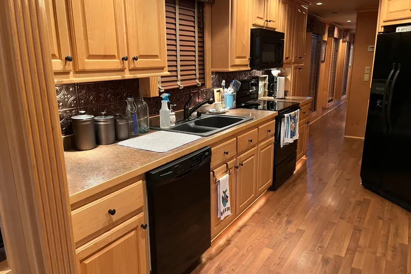 Slide: The Image of Spacious kitchen in 2010 Funtime 68x16 houseboat with wooden cabinets and modern appliances. - 12
