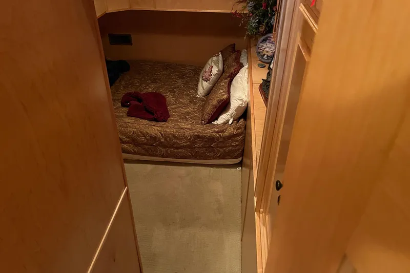 Slide: The Image of Cozy bedroom in 2010 Funtime 68x16 houseboat with decorative pillows and wooden interior. - 14