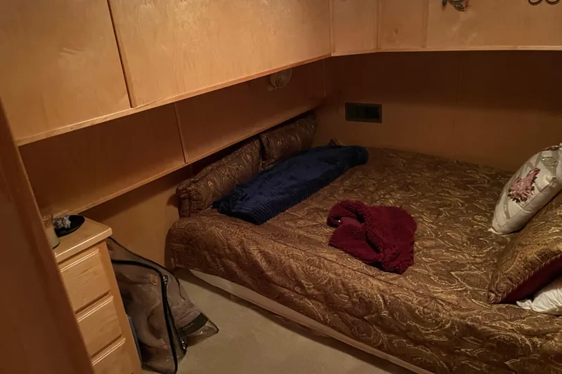 Slide: The Image of Cozy bedroom in 2010 Funtime 68x16 houseboat with wooden cabinets and patterned bedding. - 15