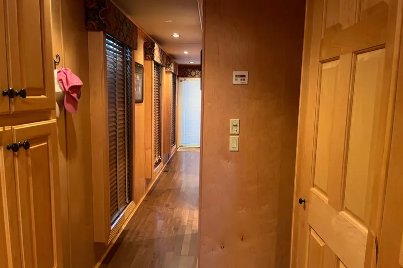 Slide: The Image of Wood-paneled hallway in 2010 Funtime 68x16 houseboat with cabinets and blinds. - 17