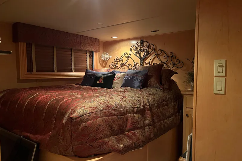 Slide: The Image of Cozy bedroom in 2010 Funtime 68x16 houseboat with elegant bedding and decorative headboard. - 22
