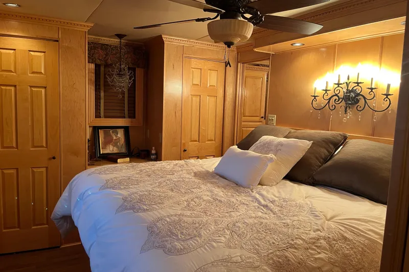 Slide: The Image of Cozy bedroom in 2010 Funtime 68x16 houseboat with elegant lighting and wooden cabinetry. - 24