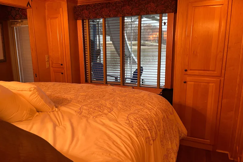 Slide: The Image of Cozy bedroom with wooden cabinets and window view on a 2010 Funtime 68x16 houseboat. - 25