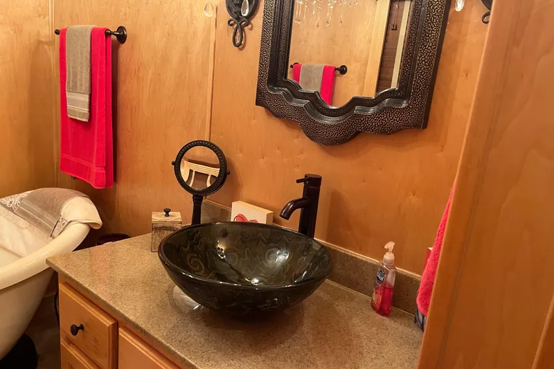 Slide: The Image of Bathroom with vessel sink, ornate mirror, and red towels in a Funtime 68x16, 2010 model. - 27
