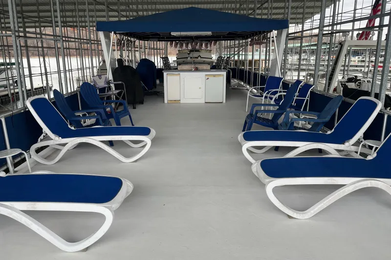 Slide: The Image of Spacious deck of 2010 Funtime 68x16 houseboat with blue lounge chairs. - 32