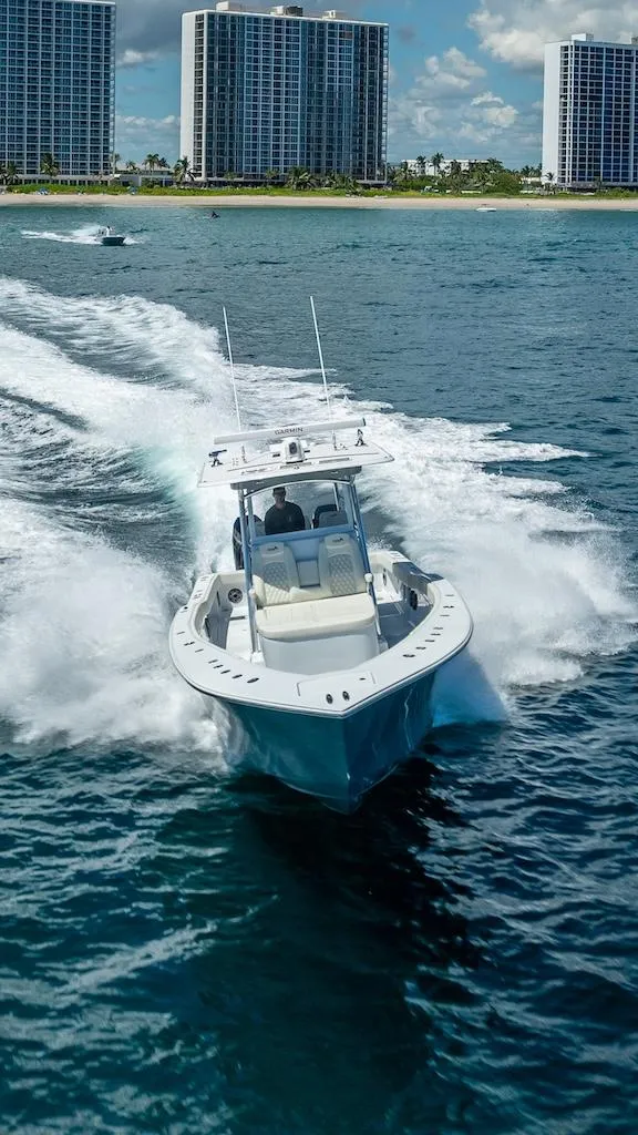Slide: The Image of 2025 Billfish 39 Center Console boat cruising near skyscrapers on a sunny day. - 29