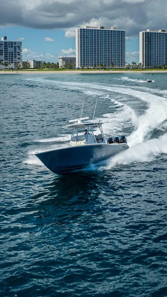 Slide: The Image of 2025 Billfish 39 Center Console boat cruising near coastal skyscrapers. - 30