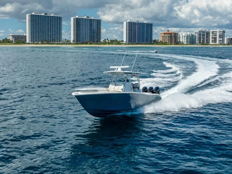 Slide: The Image of 2025 Billfish 39 Center Console boat cruising near coastal skyscrapers. - 31