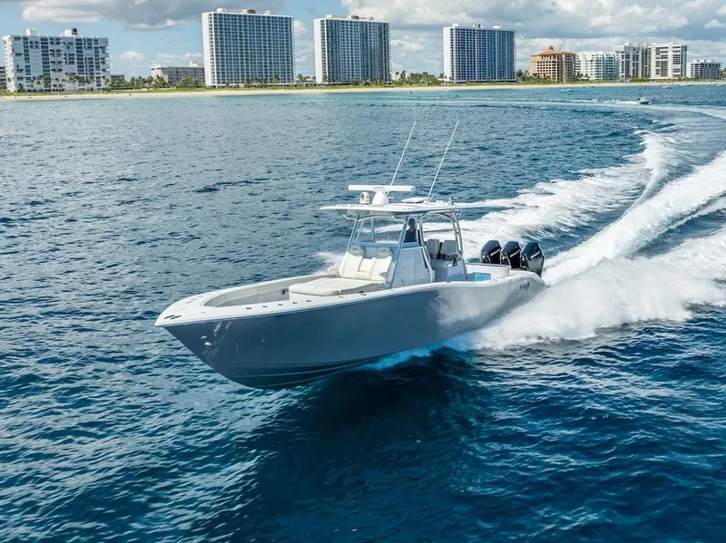 Slide: The Image of 2025 Billfish 39 Center Console boat cruising near coastal city skyline. - 33
