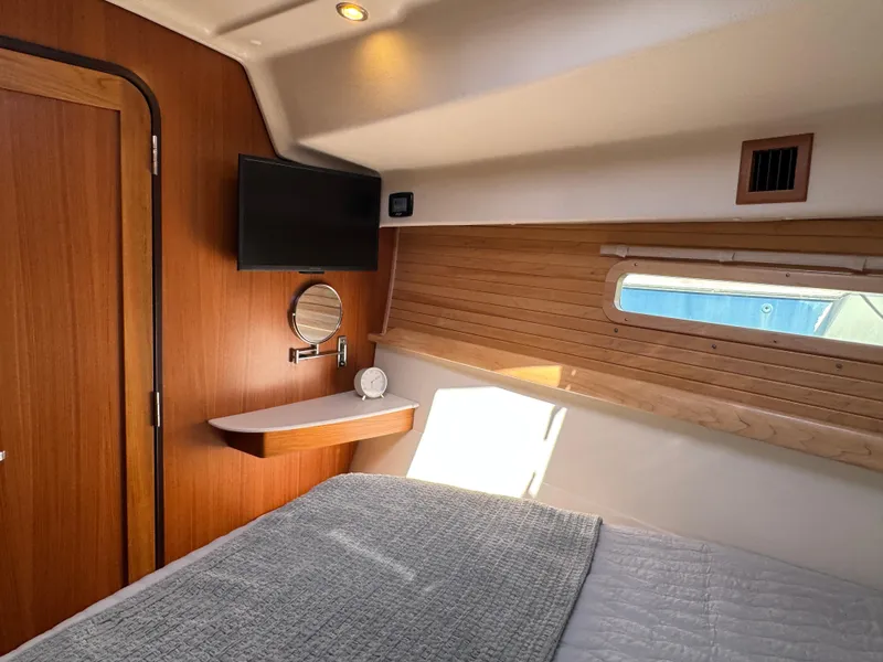 Slide: The Image of Interior of 2025 Catalina 426 yacht cabin with bed, TV, and window. - 36