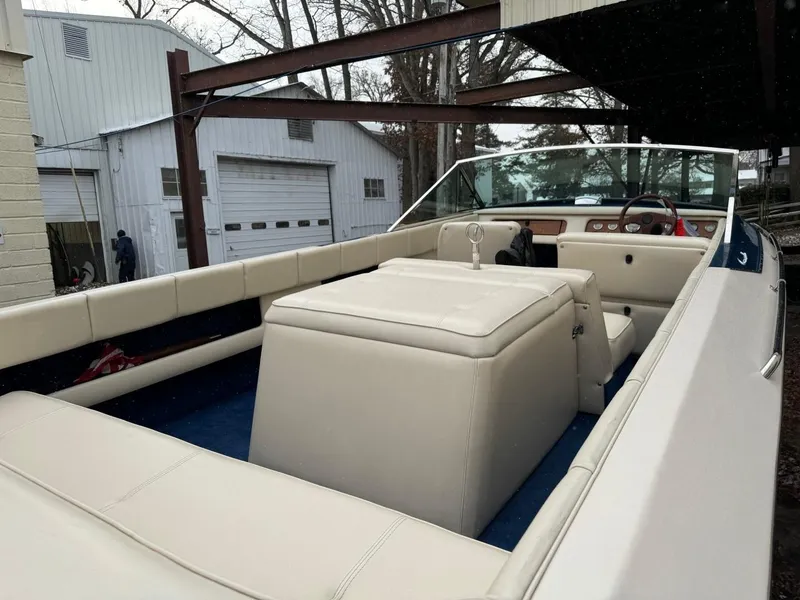 Slide: The Image of 1998 Century Coronado boat with beige interior, parked under a metal canopy. - 10