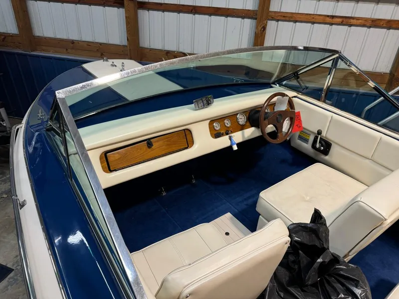 Slide: The Image of 1998 Century Coronado boat interior with blue and white seating, wooden dashboard, and steering wheel. - 17