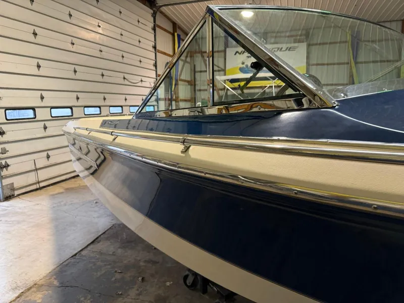 Slide: The Image of 1998 Century Coronado boat in garage, showcasing sleek blue and white design. - 24