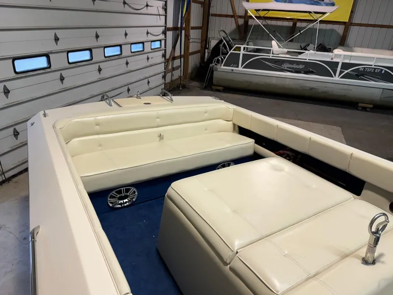 Slide: The Image of 1998 Century Coronado boat interior with cream seating in a garage. - 25