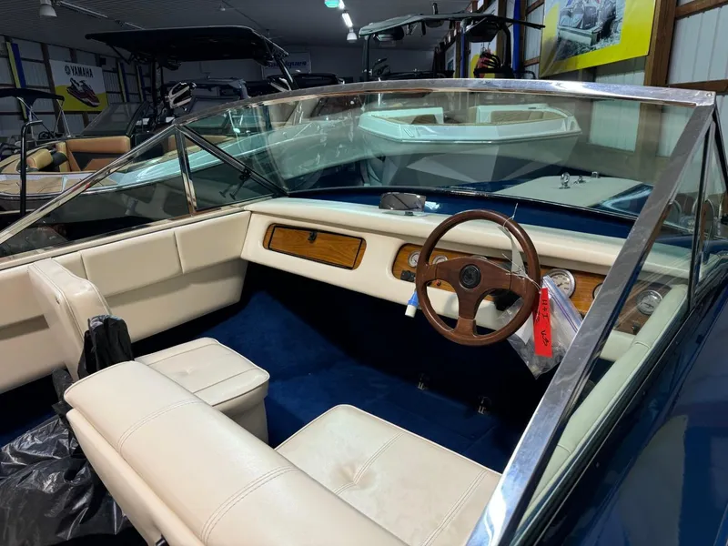 Slide: The Image of 1998 Century Coronado boat interior with white seats and wooden steering wheel. - 26