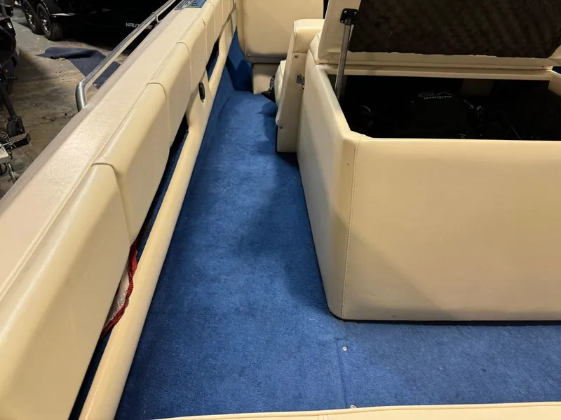Slide: The Image of Interior of a 1998 Century Coronado boat with blue carpet and beige seating. - 31